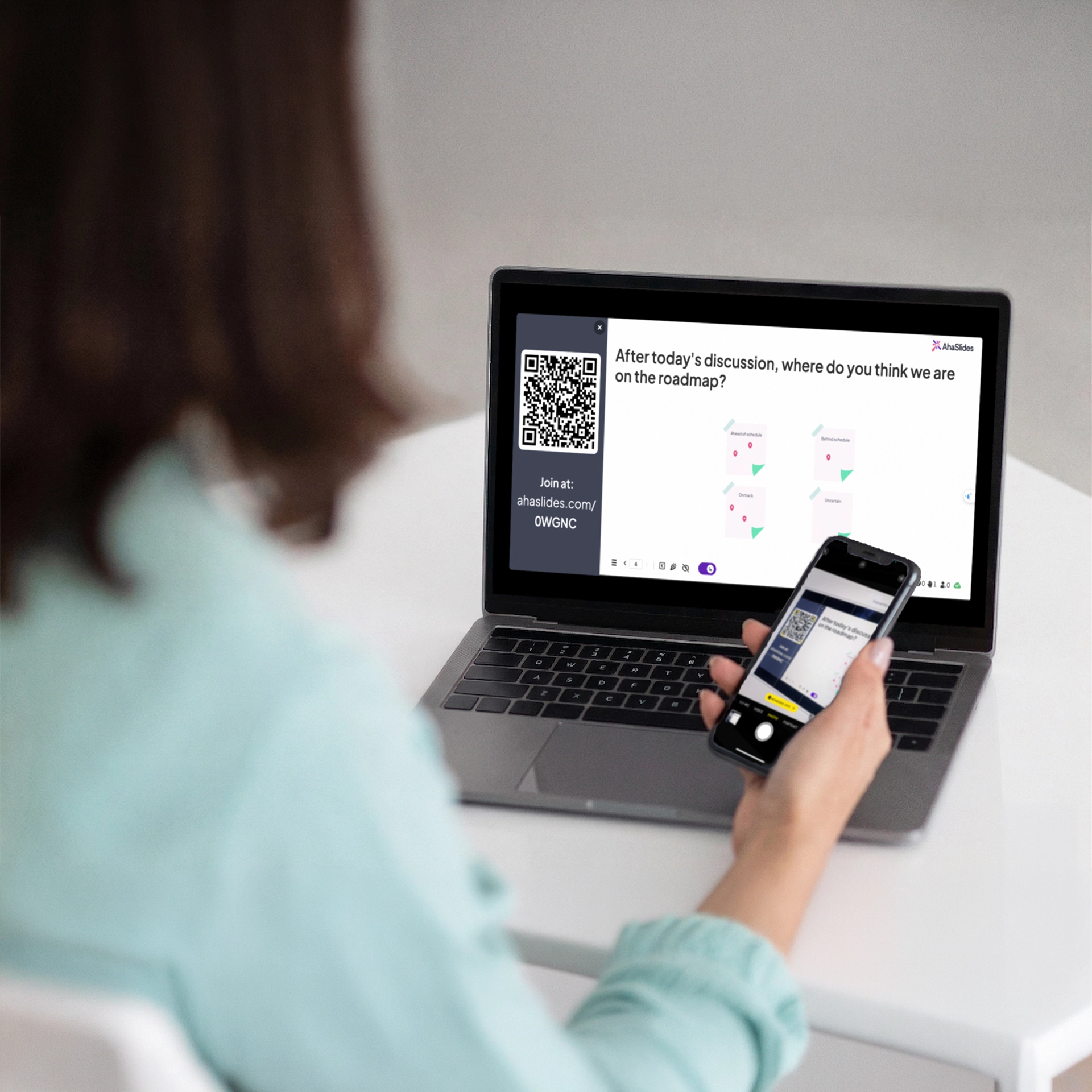 A women using her phone to scan the join code on AhaSlides