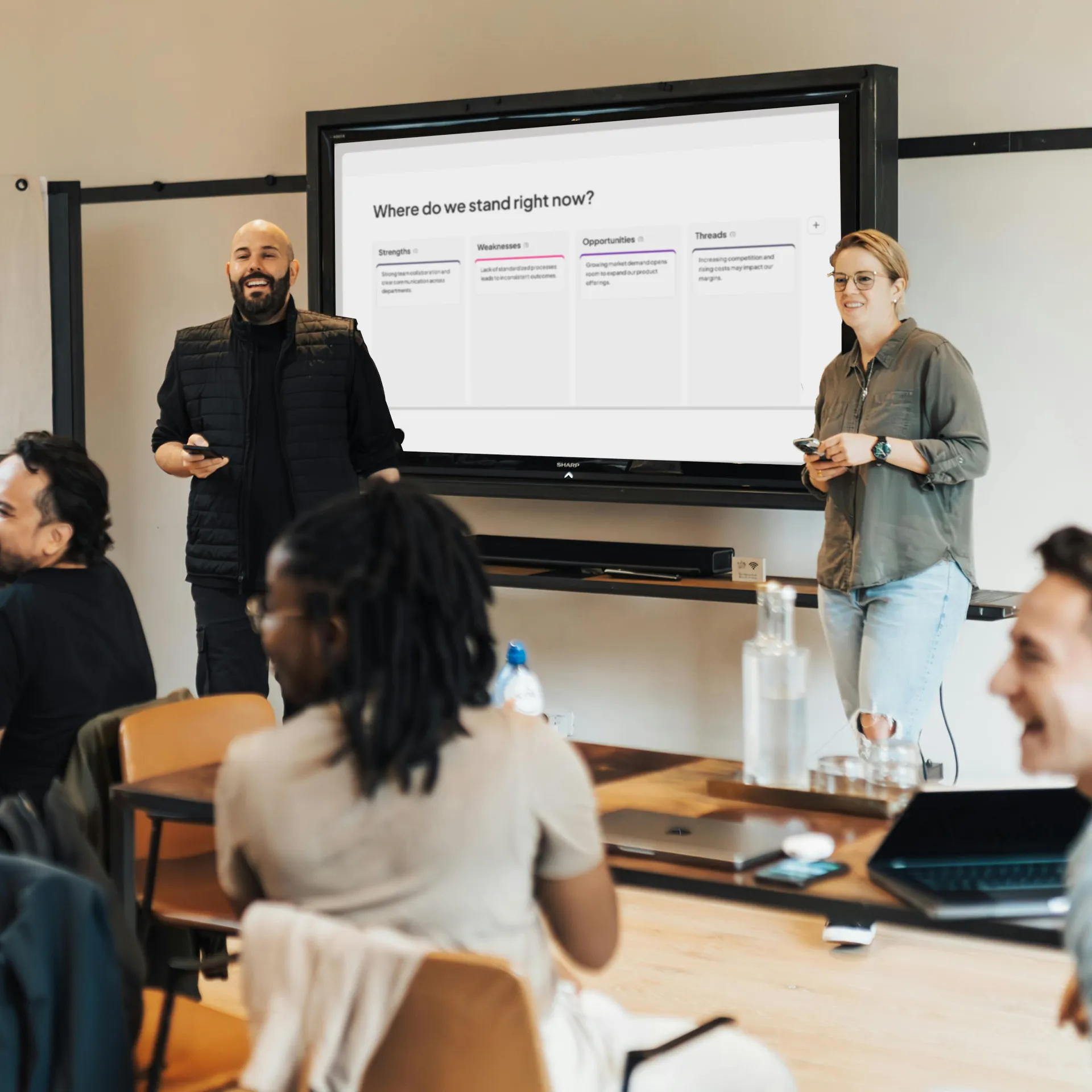 Un team in riunione utilizza il sondaggio di classificazione di AhaSlides per confrontare le iniziative e stabilire le priorità.