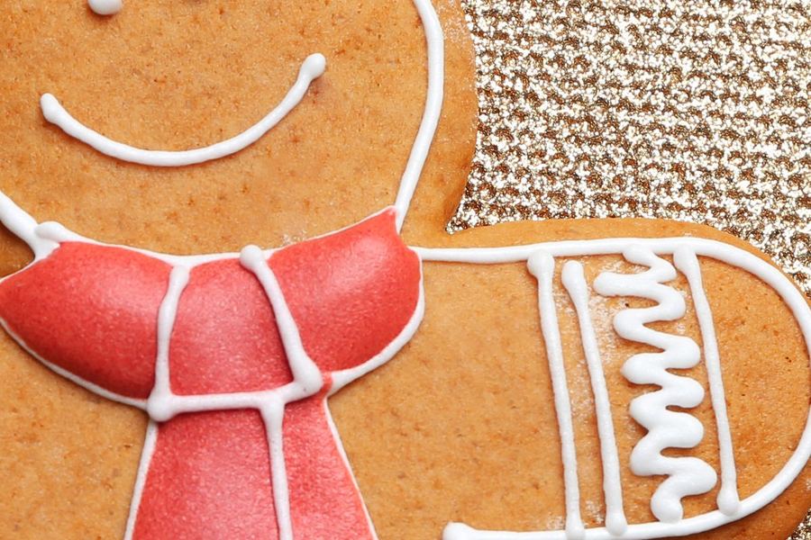 Otázka 3: Detailní záběr na usměvavou sušenkovou tvář s červenou polevou v šátku