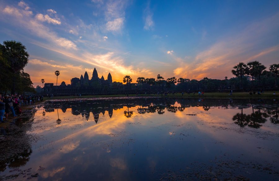 Ang silweta ng mga tore ng templo ng Angkor Wat ay makikita sa tubig na hindi gumagalaw sa paglubog ng araw