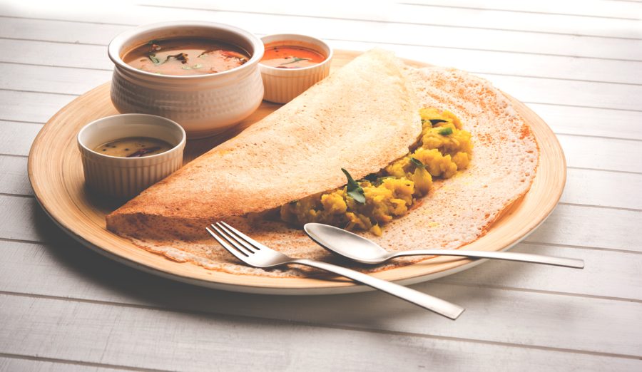 Pietų Indijos masala dosa, patiekiama su mažais dubenėliais čatnio