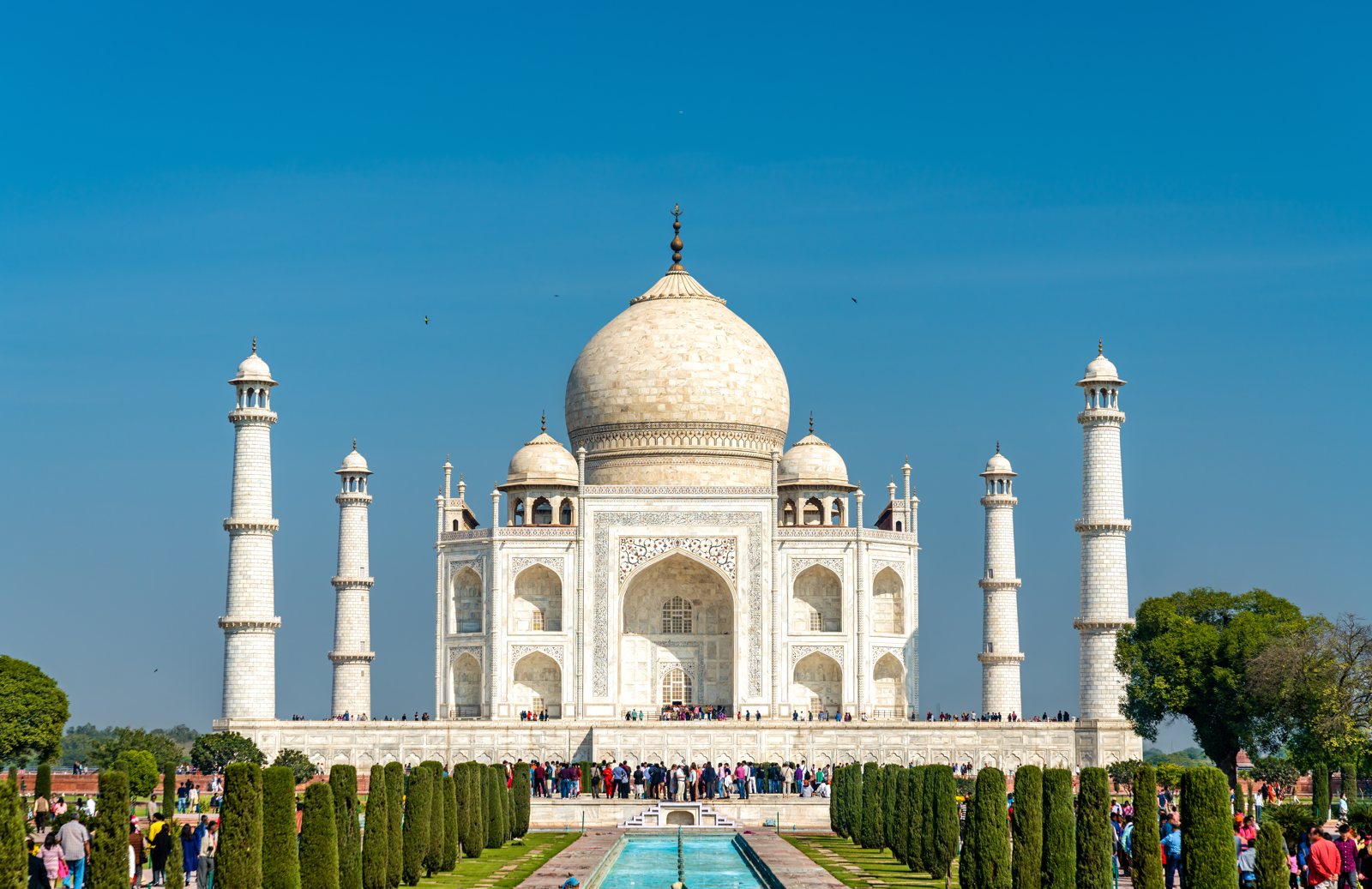 Ang Taj Mahal, isang puting marmol na mausoleum na may gitnang simboryo at apat na minarete, na makikita sa kabila ng mahabang nagrereplekta nitong lawa