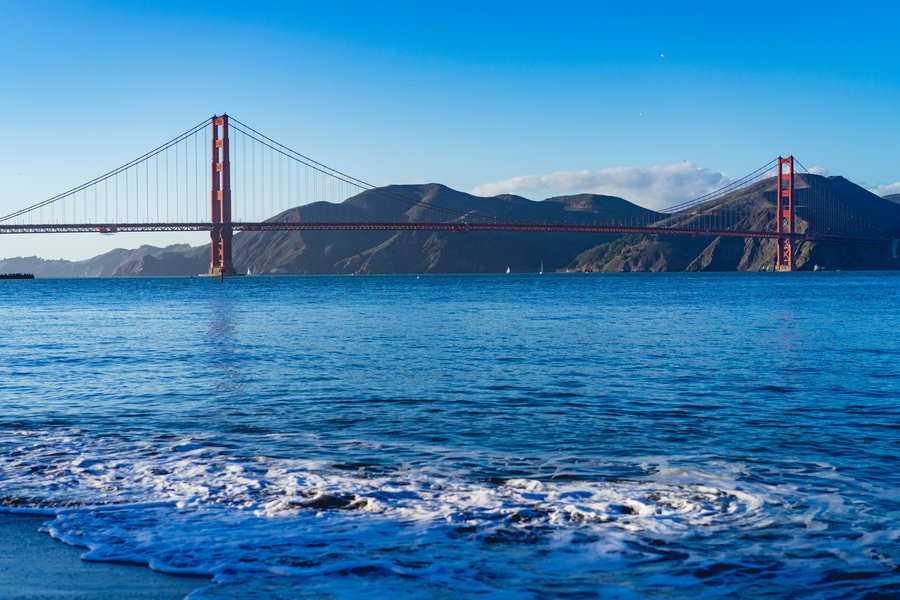 Oranžinės ir raudonos spalvos Auksinių vartų tiltas, kertantis San Francisko įlanką