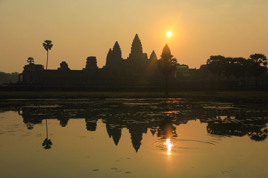 Angkor Vato bokštų siluetas atsispindi ežere saulėtekio metu Kambodžoje