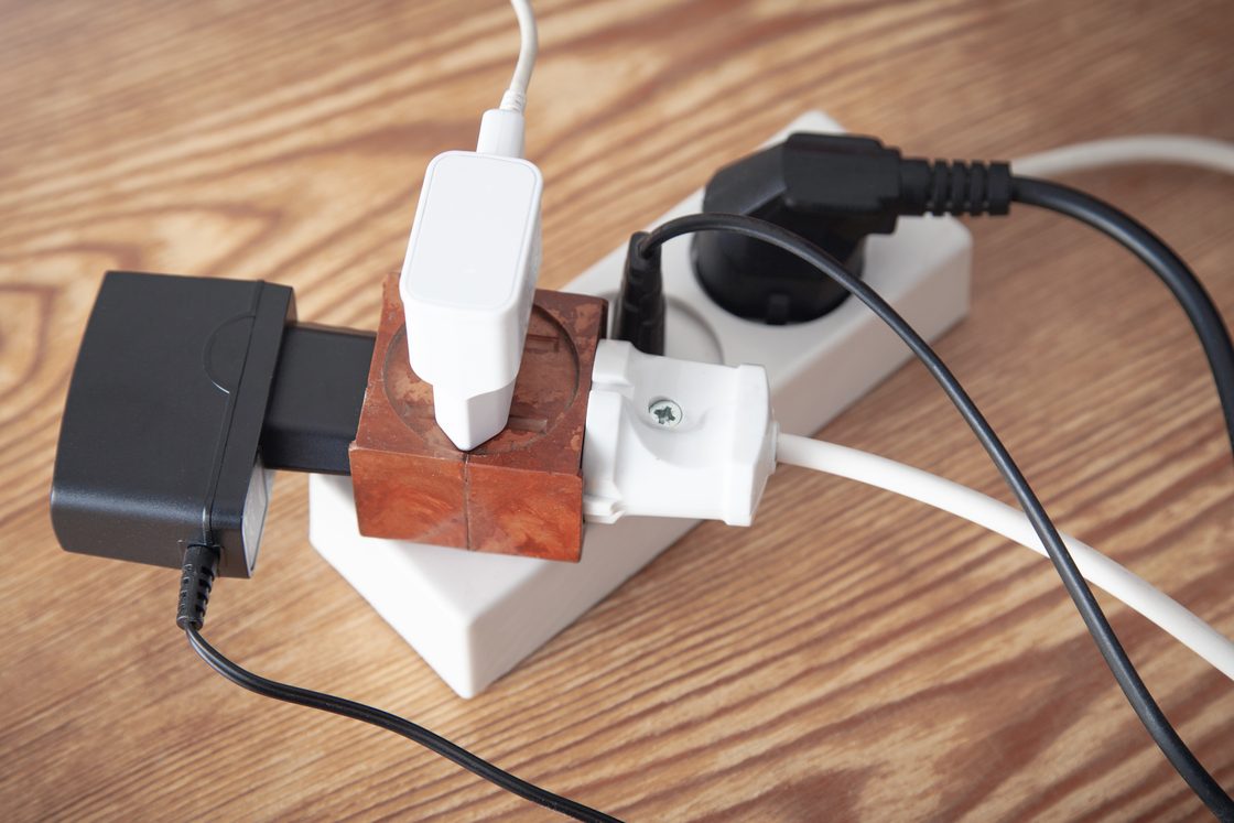 Sebuah adaptor berbentuk kubus pada kabel ekstensi dengan pengisi daya terpasang di dalamnya dan beberapa pengisi daya lainnya di sampingnya.