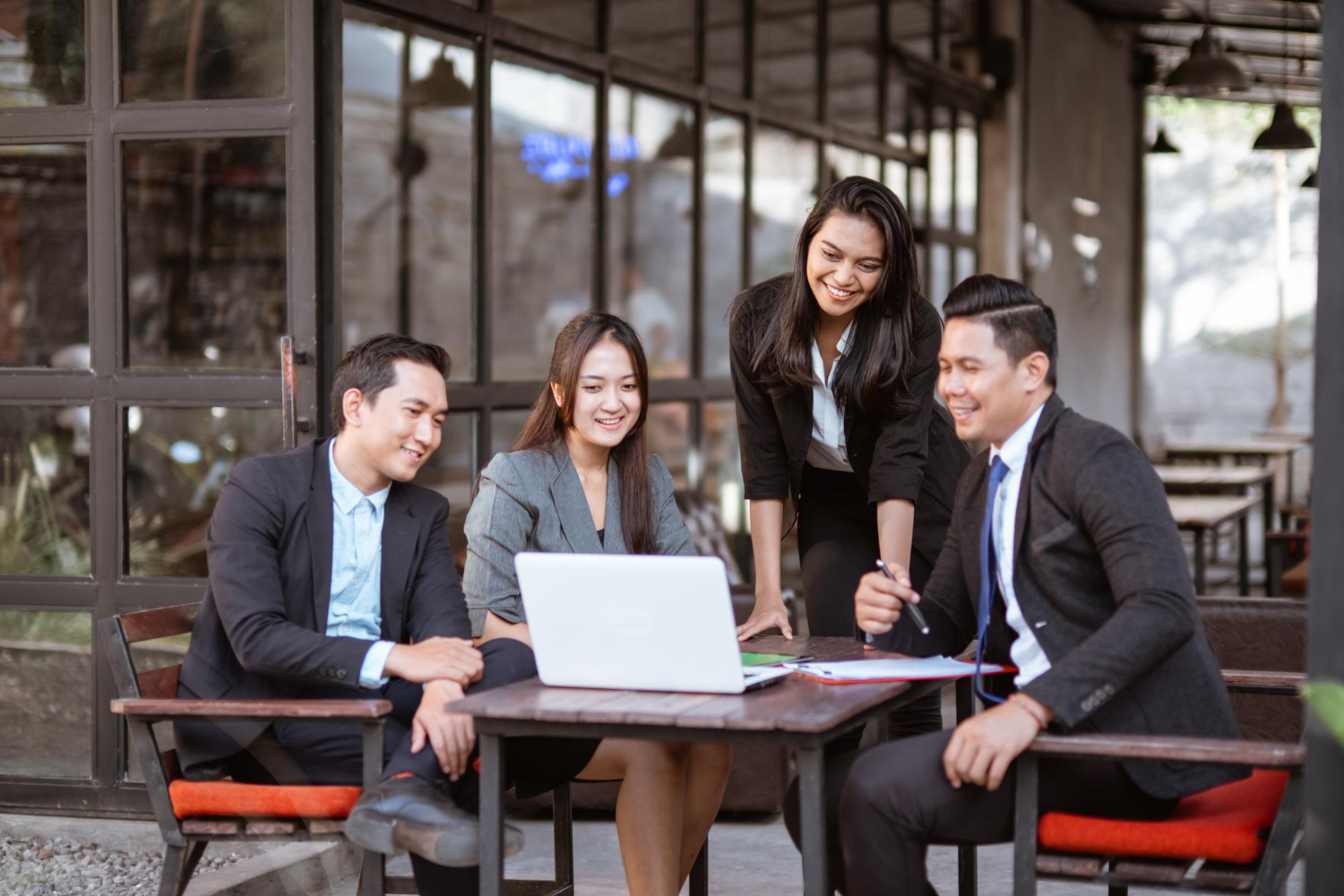 A group of colleagues discussing while looking at the laptop