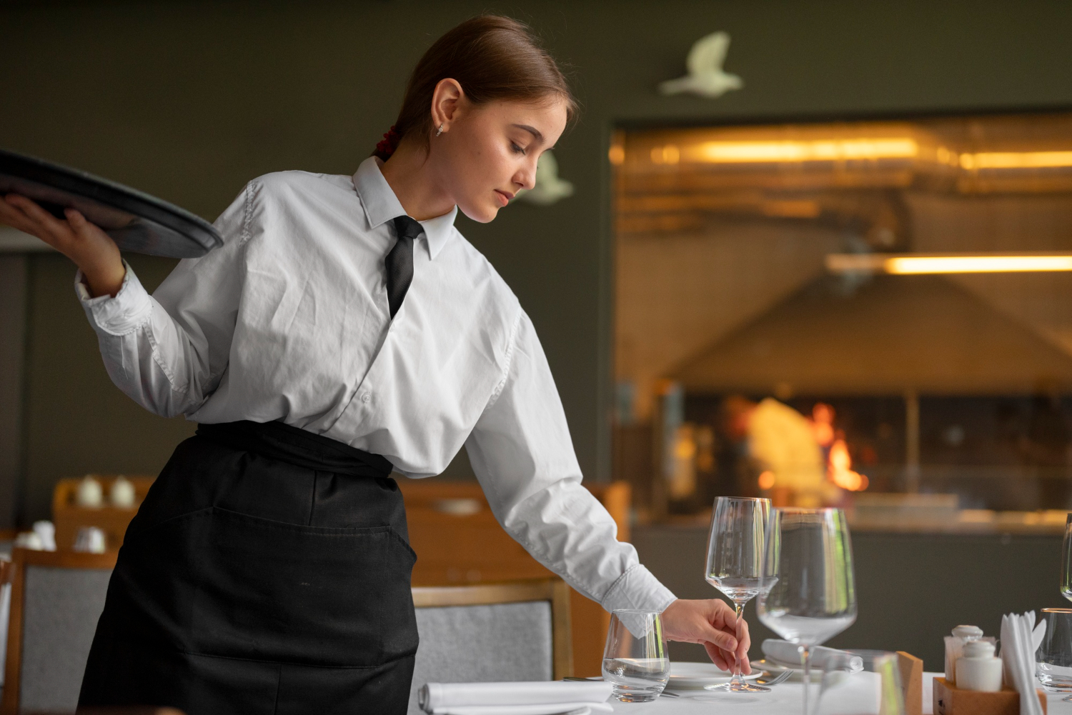 A hospitality staff setting the table