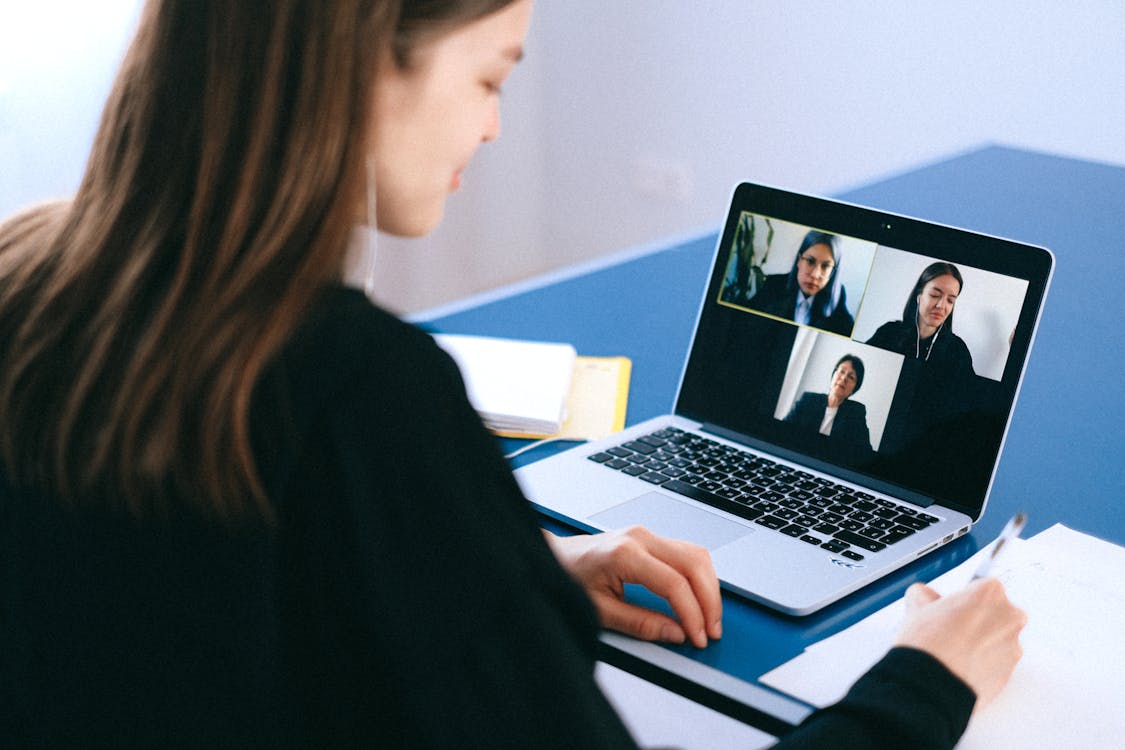 Woman participating in a virtual strategic meeting via video call on her laptop
