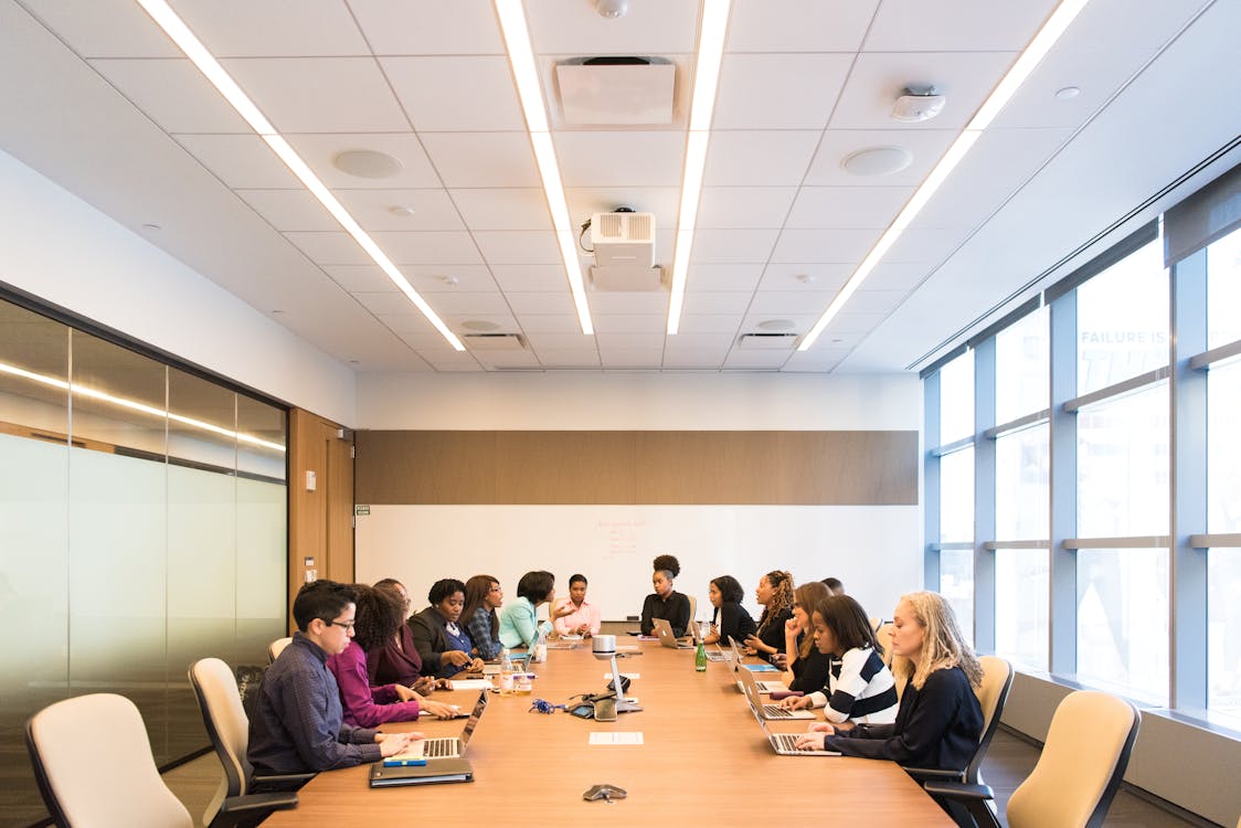Group of professionals seated around a large conference table during a strategic management meeting