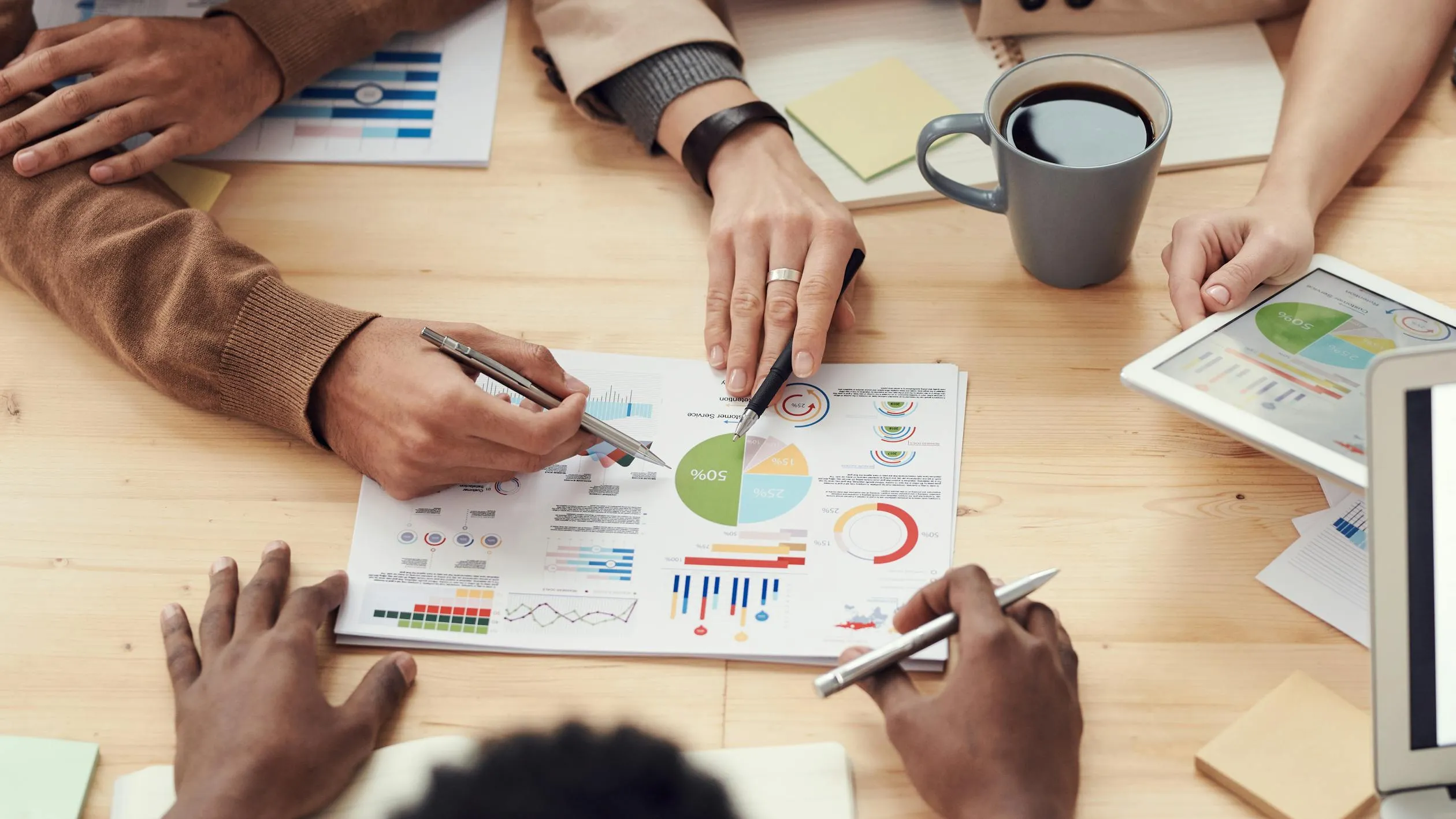 Ein Team von Fachleuten analysiert Diagramme und Grafiken aus Umfragedaten an einem Konferenztisch.
