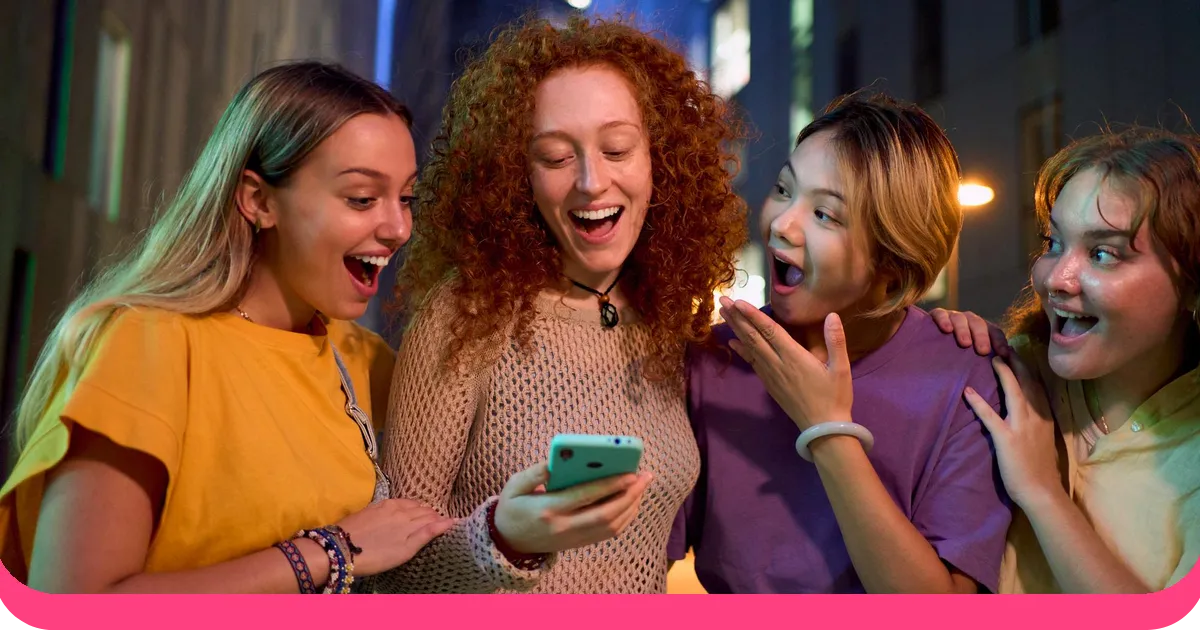 Friends laughing together while checking a phone during a movie trivia guessing game