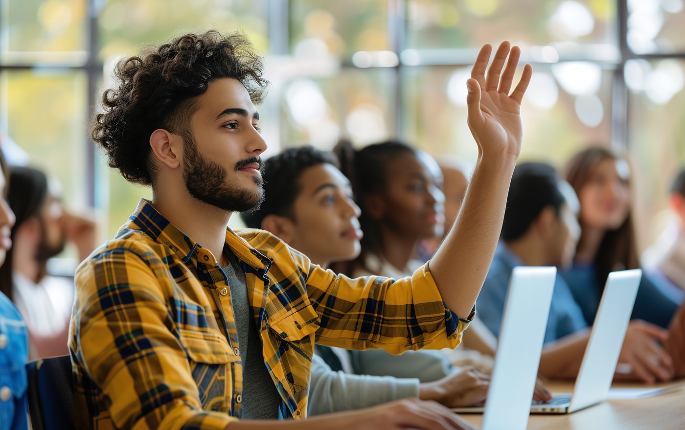 Universitātes students paceļ roku, lai atbildētu uz jautājumu stundā