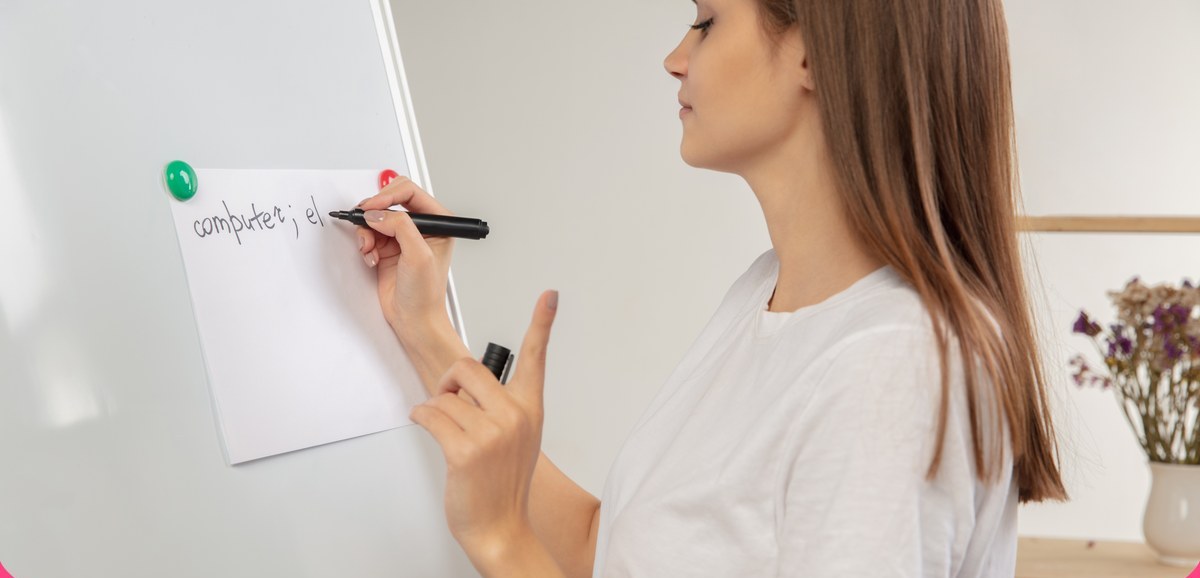 A teacher writing a word on a flipchart during an English lesson