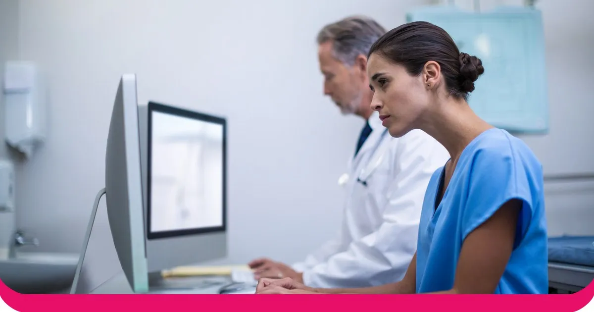 En sygeplejerske og en læge arbejder ved en hospitalscomputer