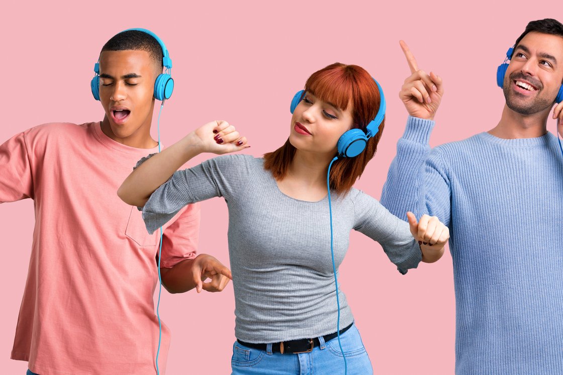 Tre venner i lyse hodetelefoner som danser til musikk mot en rosa bakgrunn