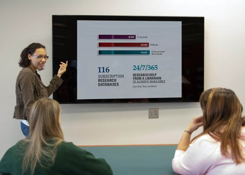 A young woman showing a presentation with a graph