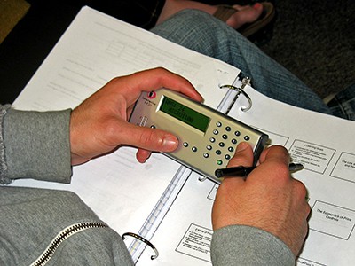 A picture showing a person using the clicker to answer a poll in class in the traditional classroom response system