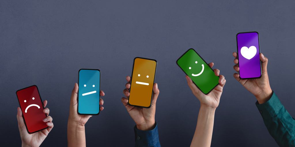 5 teléfonos con diferentes colores que expresan una cara diferente contra un fondo negro