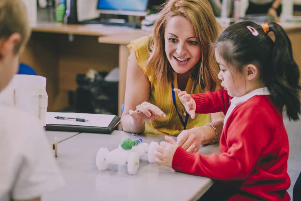 A teacher guiding her young student on her project,